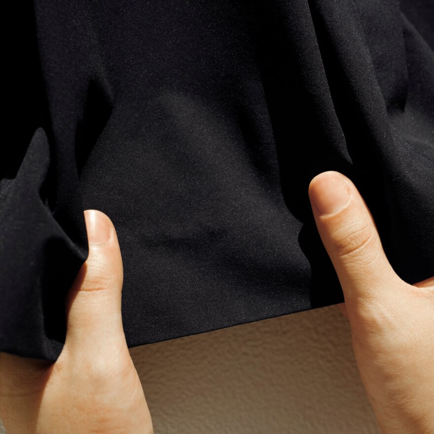 洋服を手で伸ばす