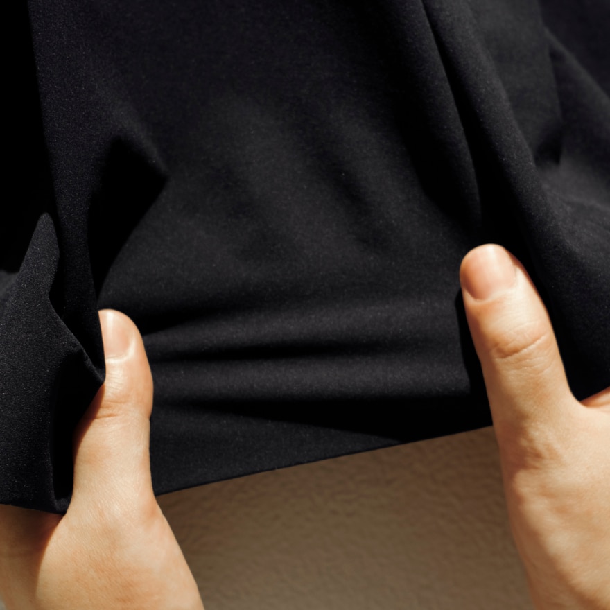 洋服を手で伸ばす