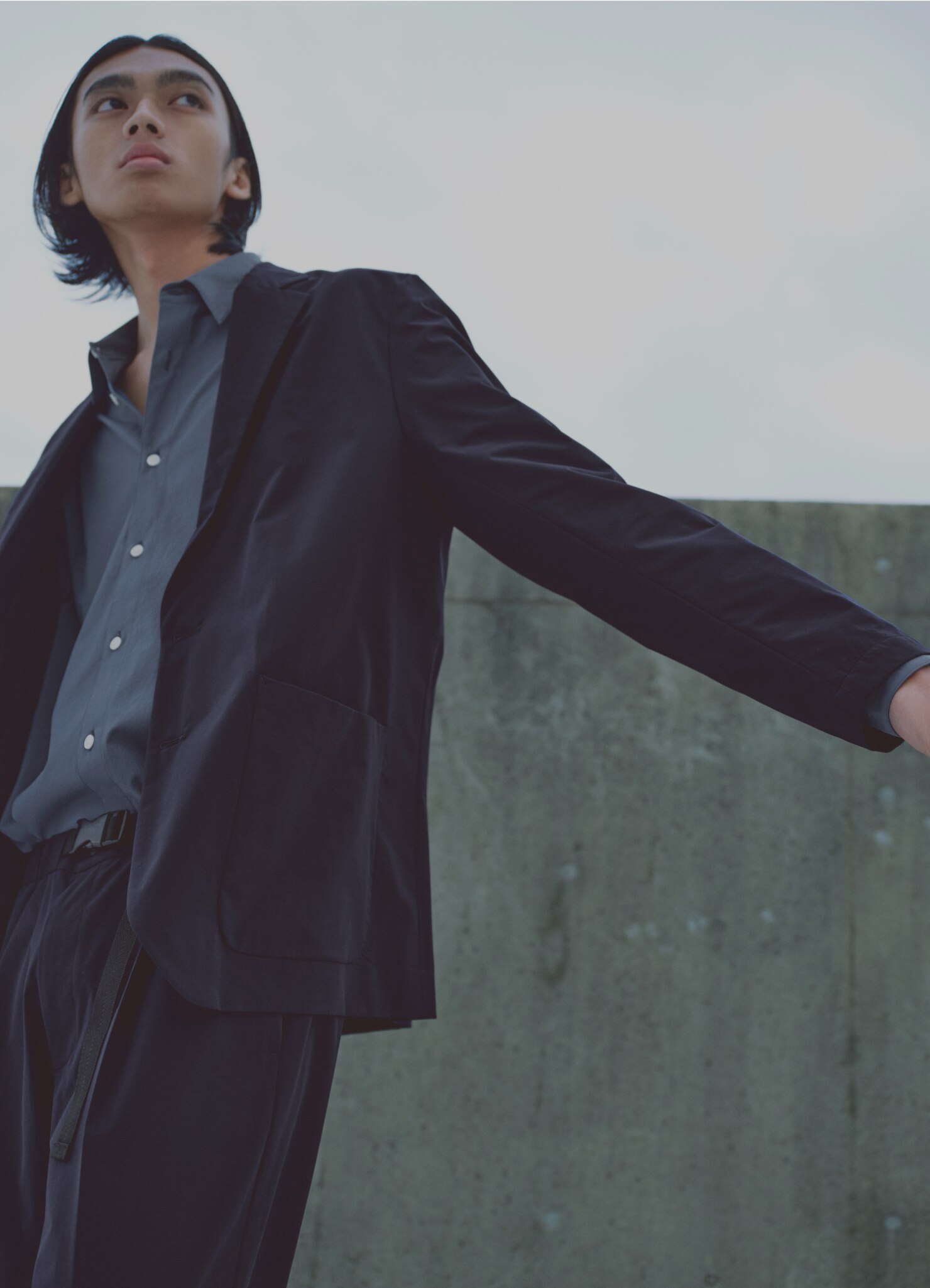 紺色のセットアップを着て上を見上げている男性