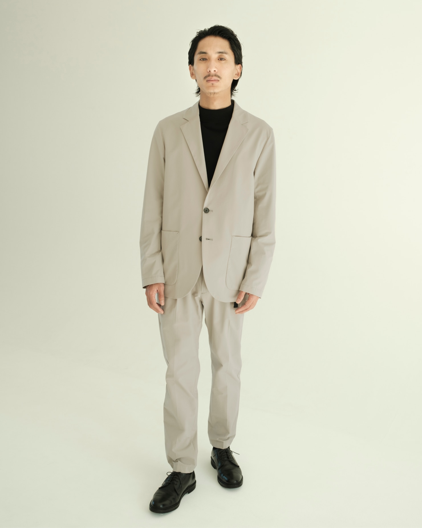 白のセットアップを着ている男性