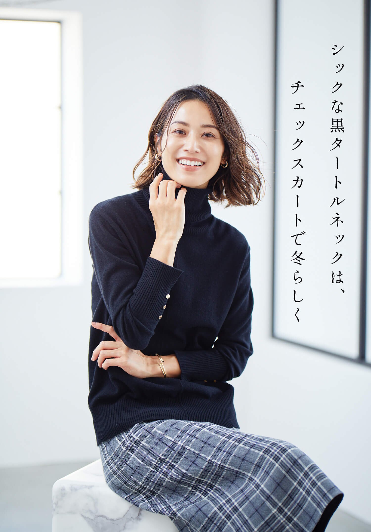 シックな黒タートルネックは、チェックスカートで冬らしく