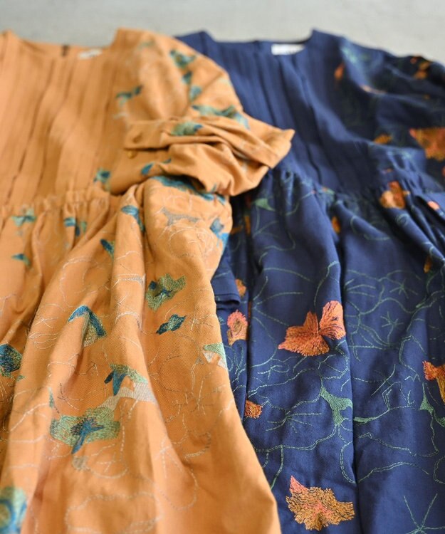 muuc 〈遠州織物の工場で作られた上質なコットンウール生地〉隠しウェスト紐有り ノーカラー ナタチュウムの花刺繍 ワンピース イエローオレンジ